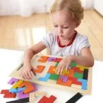 girl playing with wodden tetris jigsaw puzzle